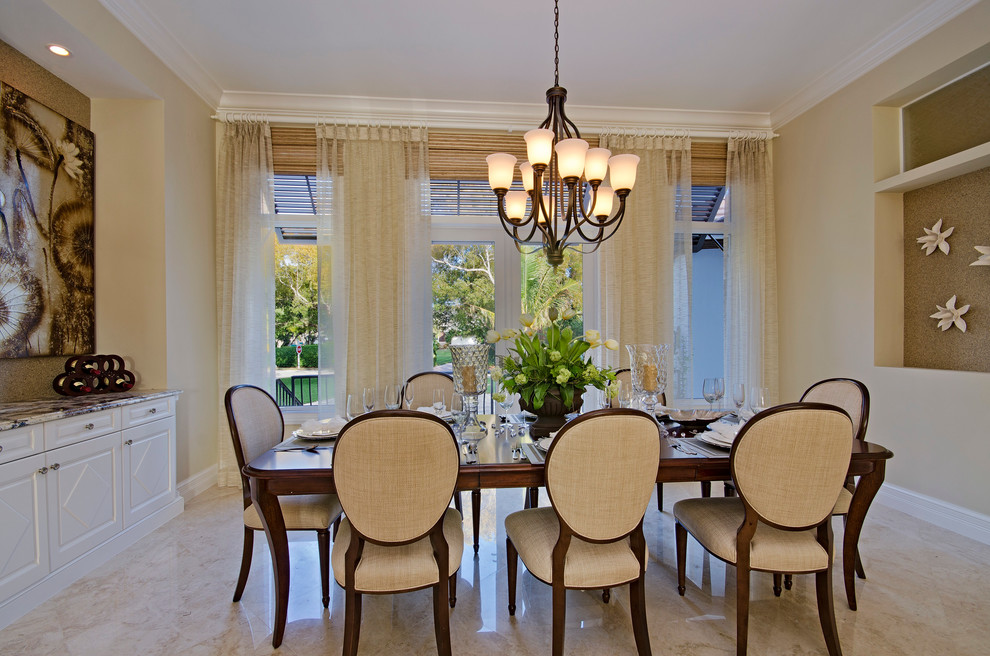 This is an example of an expansive transitional separate dining room in Miami with beige walls, marble floors and no fireplace.