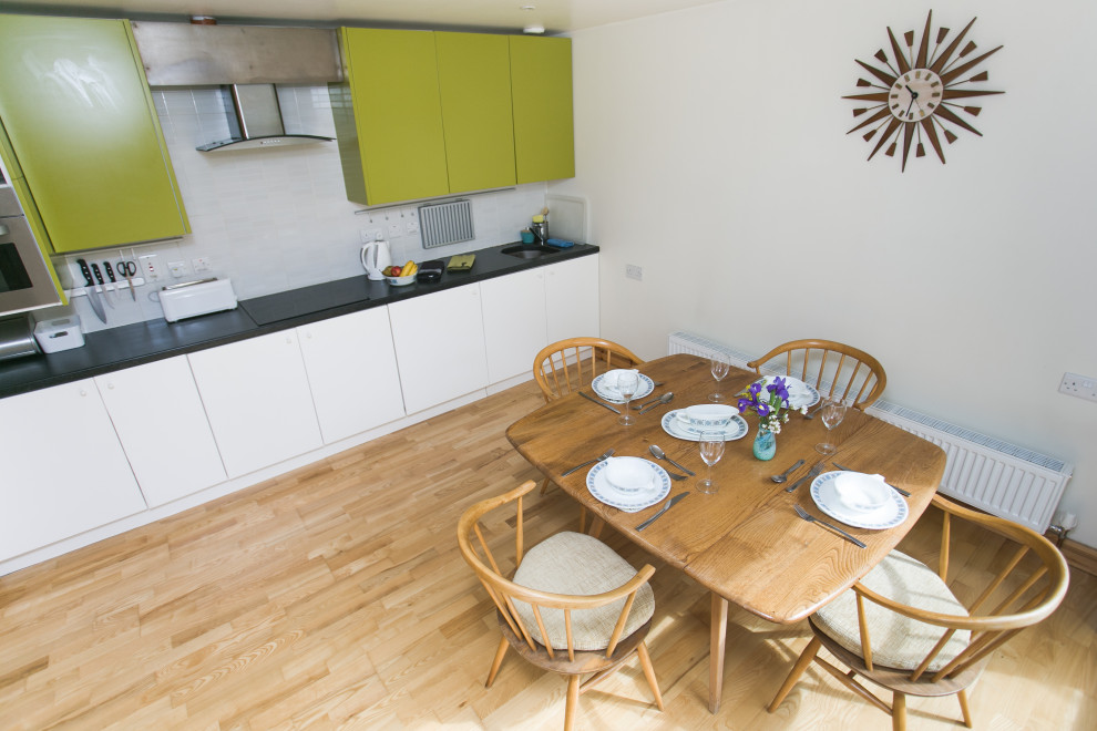 Esempio di una sala da pranzo aperta verso la cucina contemporanea di medie dimensioni con parquet chiaro