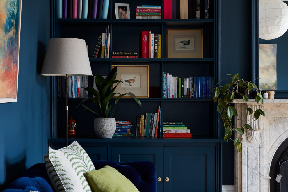 Esempio di un grande soggiorno vittoriano con pareti blu, pavimento in legno massello medio, camino classico e con abbinamento di mobili antichi e moderni