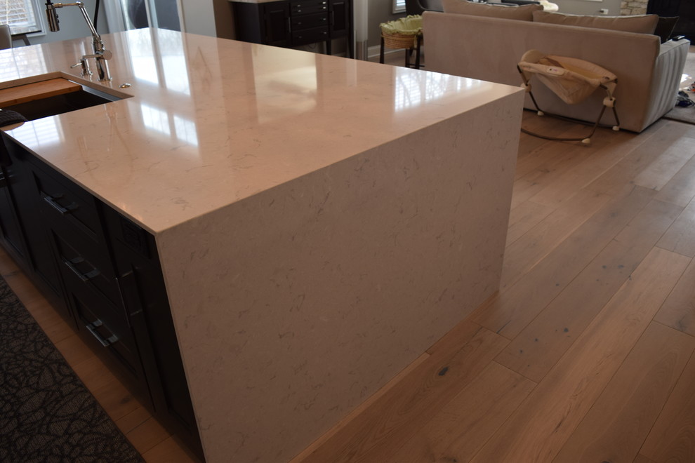 Eat-in kitchen - large transitional l-shaped light wood floor and multicolored floor eat-in kitchen idea in Chicago with beaded inset cabinets, white cabinets, quartz countertops, black backsplash, ceramic backsplash, stainless steel appliances and an island