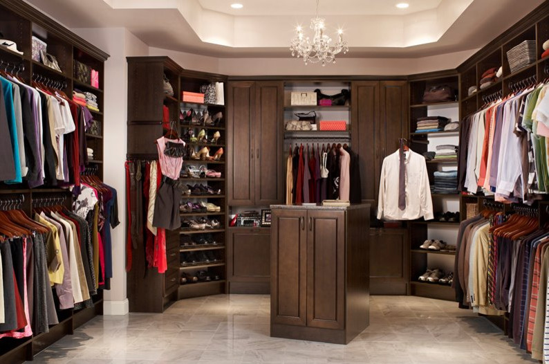 This is an example of an expansive traditional gender-neutral walk-in wardrobe in Toronto with raised-panel cabinets, dark wood cabinets, ceramic floors and grey floor.