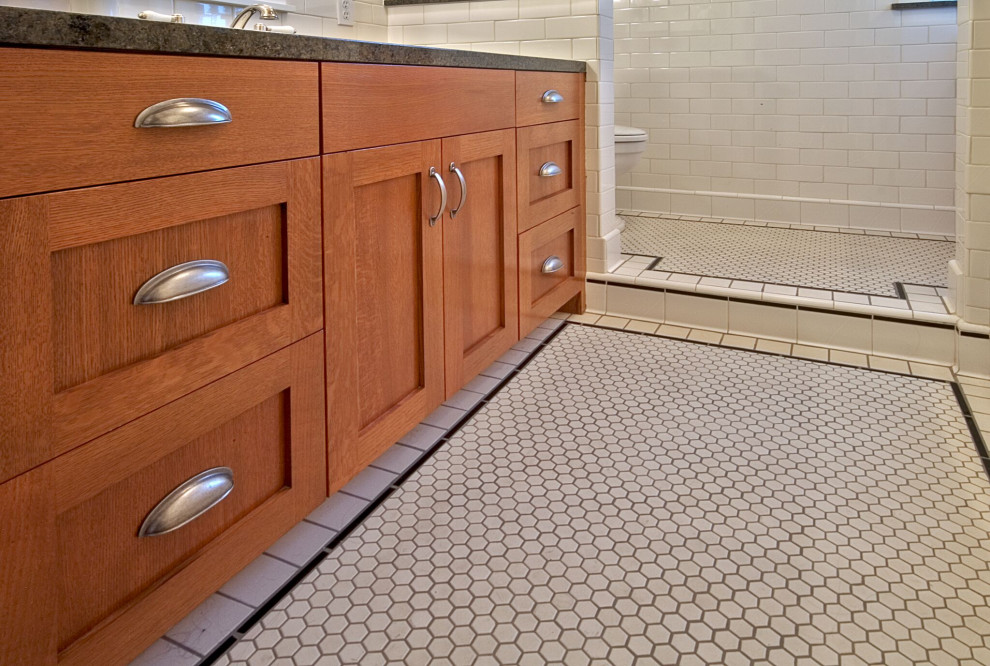 Design ideas for an arts and crafts bathroom in Seattle with shaker cabinets, medium wood cabinets, white tile, subway tile, beige walls, ceramic floors, an undermount sink, granite benchtops, white floor and black benchtops.