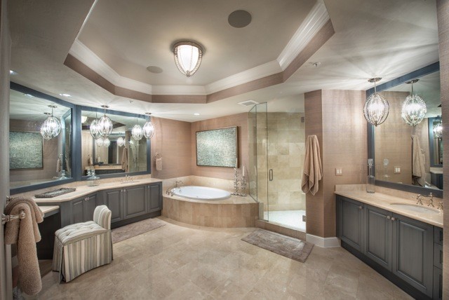 Design ideas for a mid-sized transitional master bathroom in Miami with raised-panel cabinets, grey cabinets, a corner tub, a corner shower, a two-piece toilet, beige tile, limestone, beige walls, limestone floors, an undermount sink and limestone benchtops.