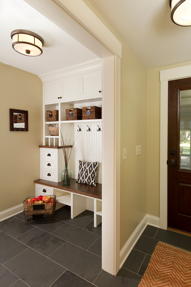 Mid-sized traditional mudroom in Minneapolis with beige walls, slate floors, a single front door and a dark wood front door.