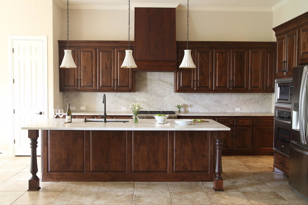 Example of a large transitional l-shaped ceramic tile and beige floor enclosed kitchen design with an undermount sink, dark wood cabinets, beige backsplash, stainless steel appliances and an island