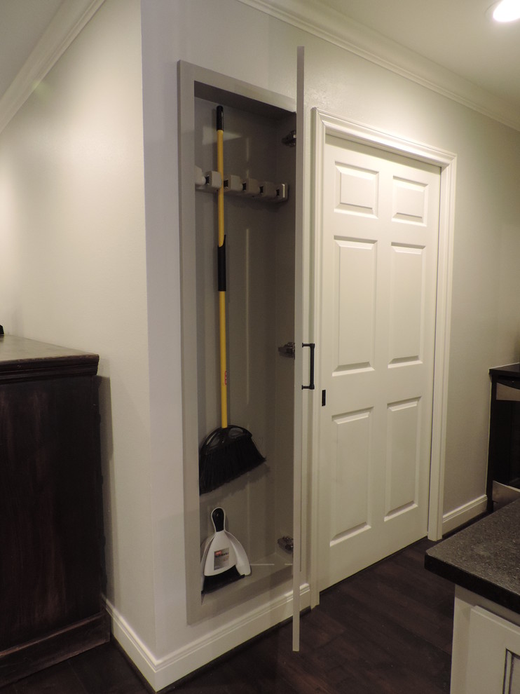 Photo of a mid-sized transitional gender-neutral built-in wardrobe in Houston with shaker cabinets, beige cabinets and dark hardwood floors.