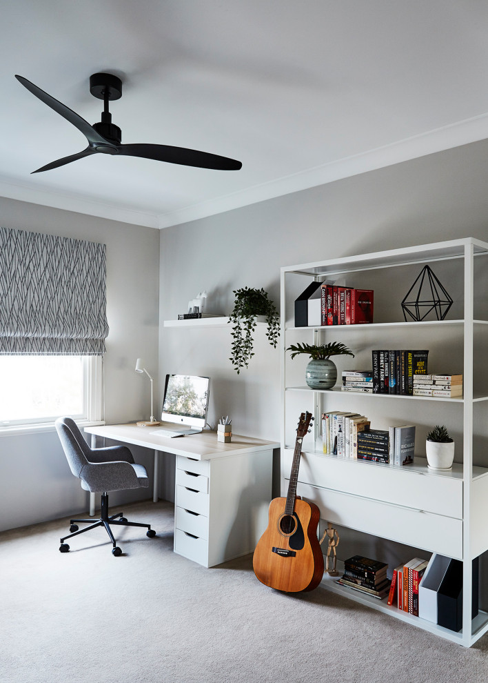 This is an example of a mid-sized contemporary study room in Sydney with grey walls, carpet, a freestanding desk and grey floor.