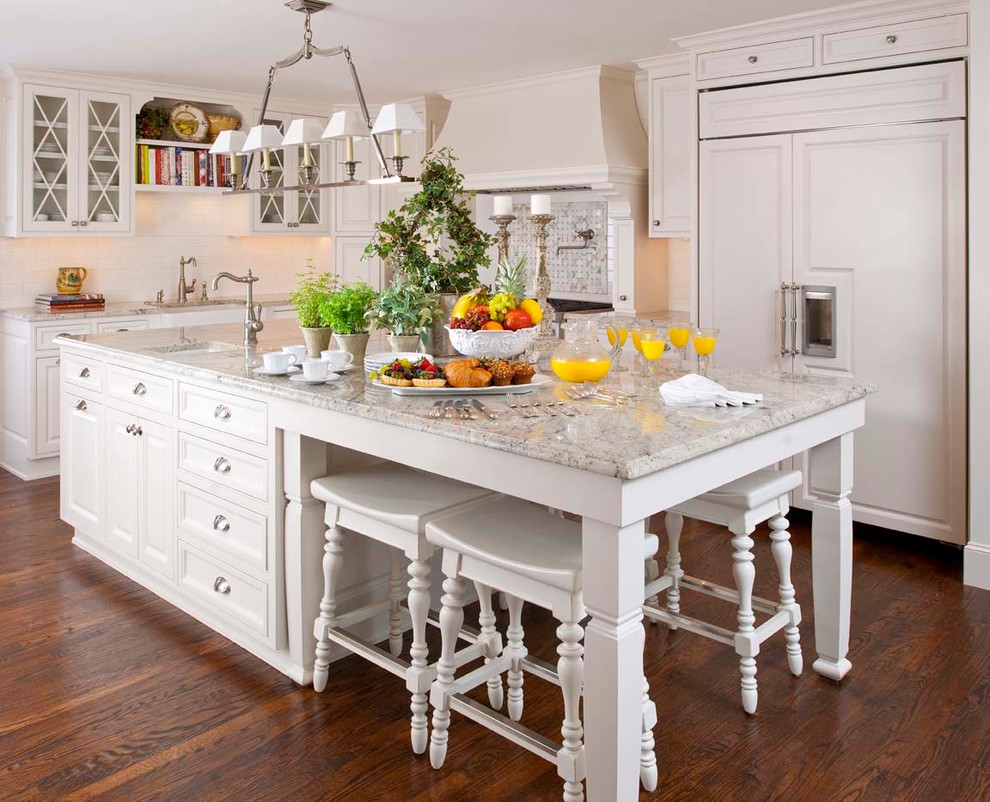Inspiration for a large transitional u-shaped medium tone wood floor and brown floor eat-in kitchen remodel in Austin with a farmhouse sink, white cabinets, granite countertops, white backsplash, ceramic backsplash, paneled appliances and an island