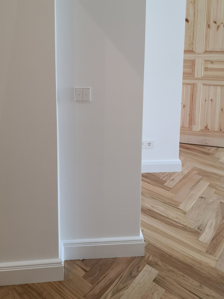 Imagen de salón abierto clásico de tamaño medio con paredes blancas, suelo de madera en tonos medios, estufa de leña, marco de chimenea de metal y suelo marrón