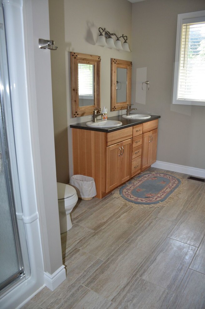 Inspiration for a mid-sized rustic master vinyl floor home design remodel in Toronto with shaker cabinets, light wood cabinets, a drop-in sink and laminate countertops