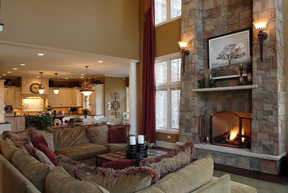 Photo of a traditional living room in Chicago with dark hardwood flooring, a standard fireplace, a stone fireplace surround, brown floors and a vaulted ceiling.