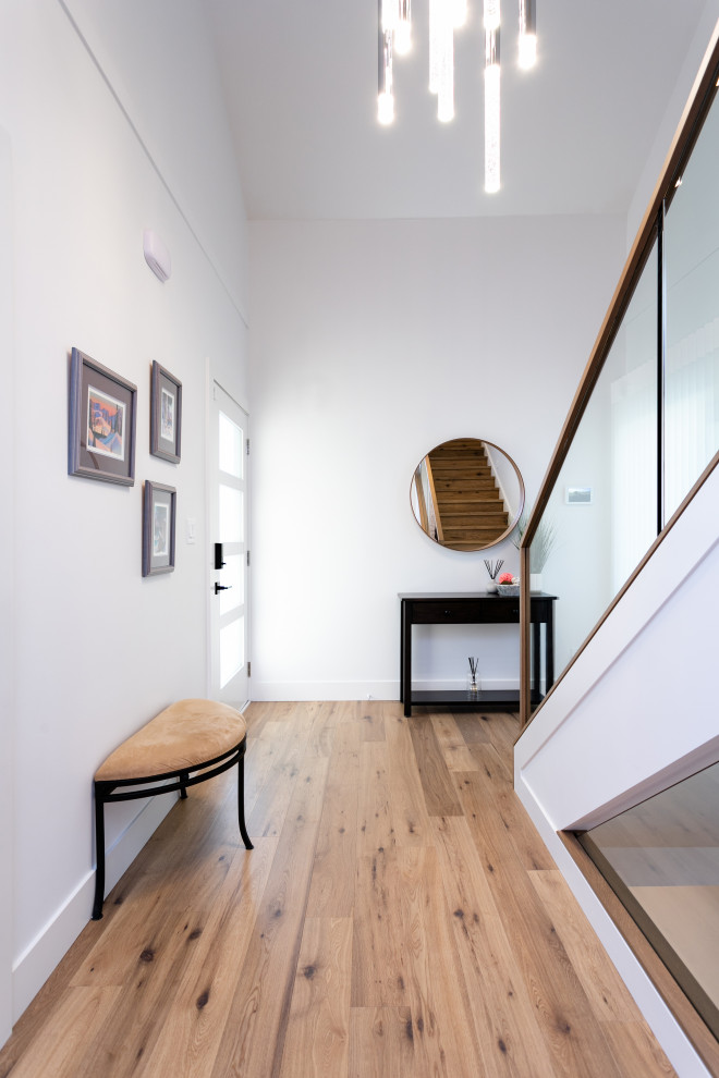 Inspiration for a mid-sized transitional medium tone wood floor and brown floor front door remodel in Vancouver with white walls and a glass front door