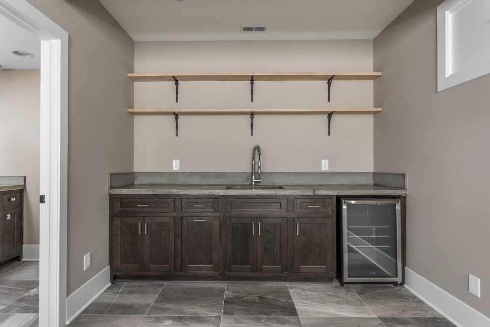 Photo of a mid-sized contemporary single-wall wet bar in Indianapolis with an undermount sink, open cabinets, concrete benchtops, ceramic floors and grey floor.