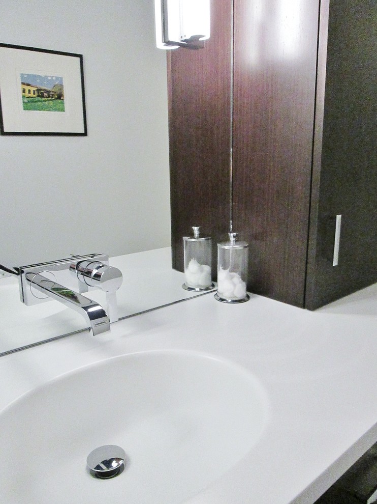 Bathroom - small transitional 3/4 white tile white floor bathroom idea in Chicago with flat-panel cabinets, dark wood cabinets, a one-piece toilet, white walls, an integrated sink and solid surface countertops