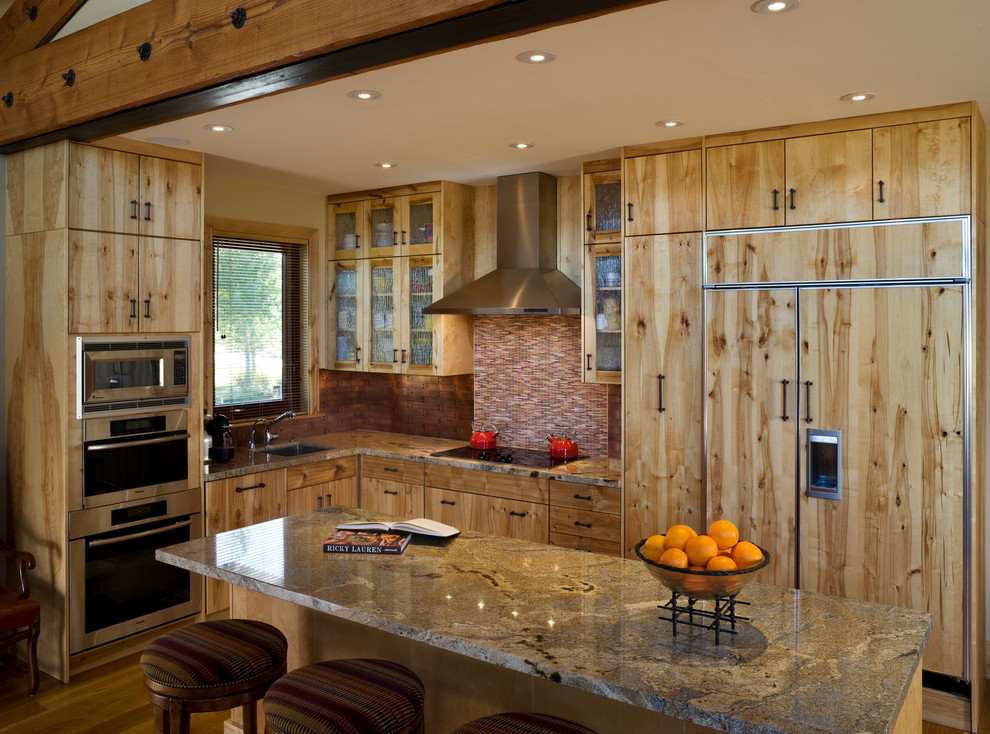 Mid-sized mountain style l-shaped medium tone wood floor kitchen photo with an undermount sink, flat-panel cabinets, light wood cabinets, paneled appliances, an island, multicolored backsplash and matchstick tile backsplash