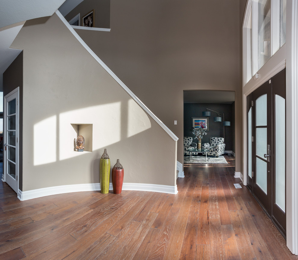 Inspiration for a huge transitional medium tone wood floor foyer remodel in Denver with beige walls and a brown front door
