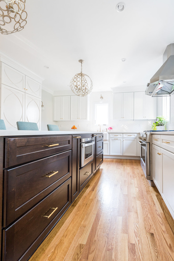 Kitchen - transitional medium tone wood floor kitchen idea in Richmond with a farmhouse sink, shaker cabinets, white cabinets, quartzite countertops, white backsplash, subway tile backsplash, stainless steel appliances and an island
