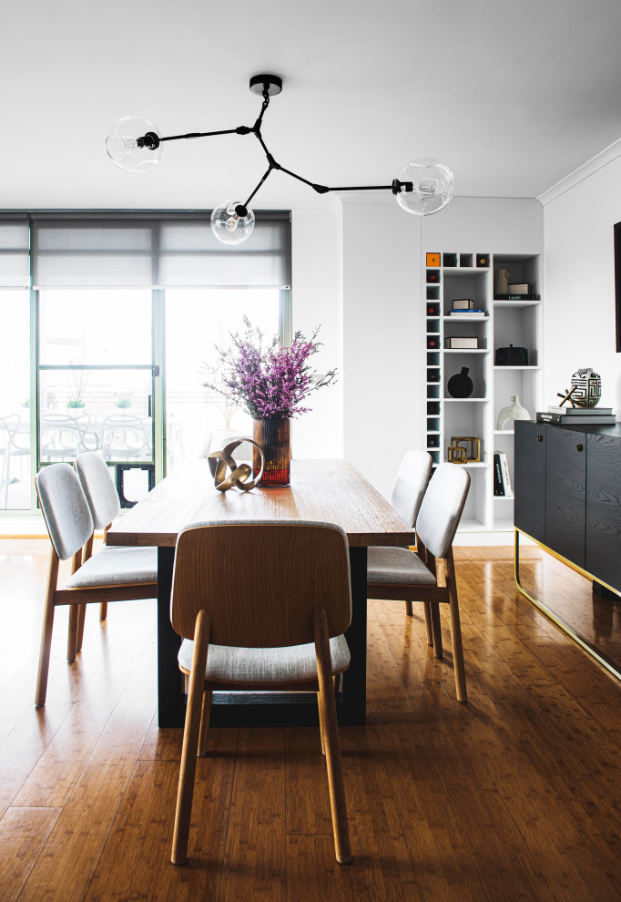 This is an example of a mid-sized eclectic open plan dining in Sydney with white walls, laminate floors and no fireplace.
