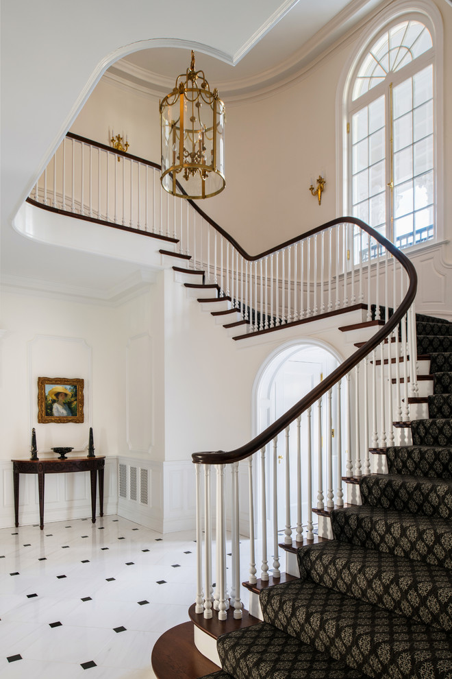 Photo of a large traditional wood curved staircase in Richmond with wood railing and painted wood risers.