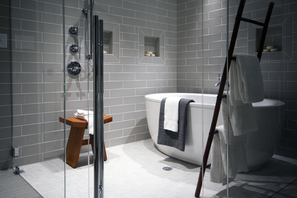 This is an example of a contemporary master bathroom in Raleigh with a freestanding tub, a curbless shower, gray tile, porcelain tile and porcelain floors.