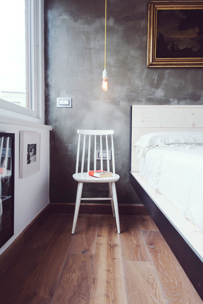 Photo of an industrial bedroom in Rome with grey walls and dark hardwood floors.