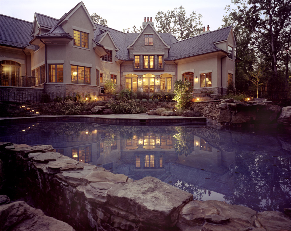 Example of a large mountain style backyard stone and custom-shaped natural pool design in DC Metro