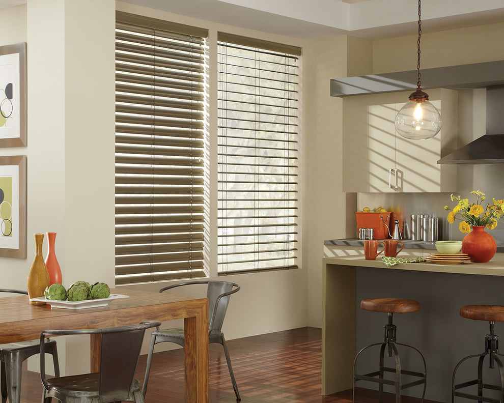 Example of a transitional dark wood floor eat-in kitchen design with flat-panel cabinets, beige cabinets, solid surface countertops and stainless steel appliances