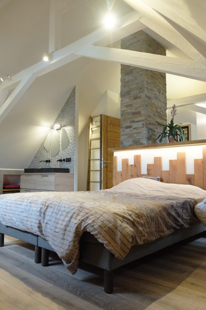 Ispirazione per una camera da letto minimalista con cornice del camino in pietra ricostruita e travi a vista