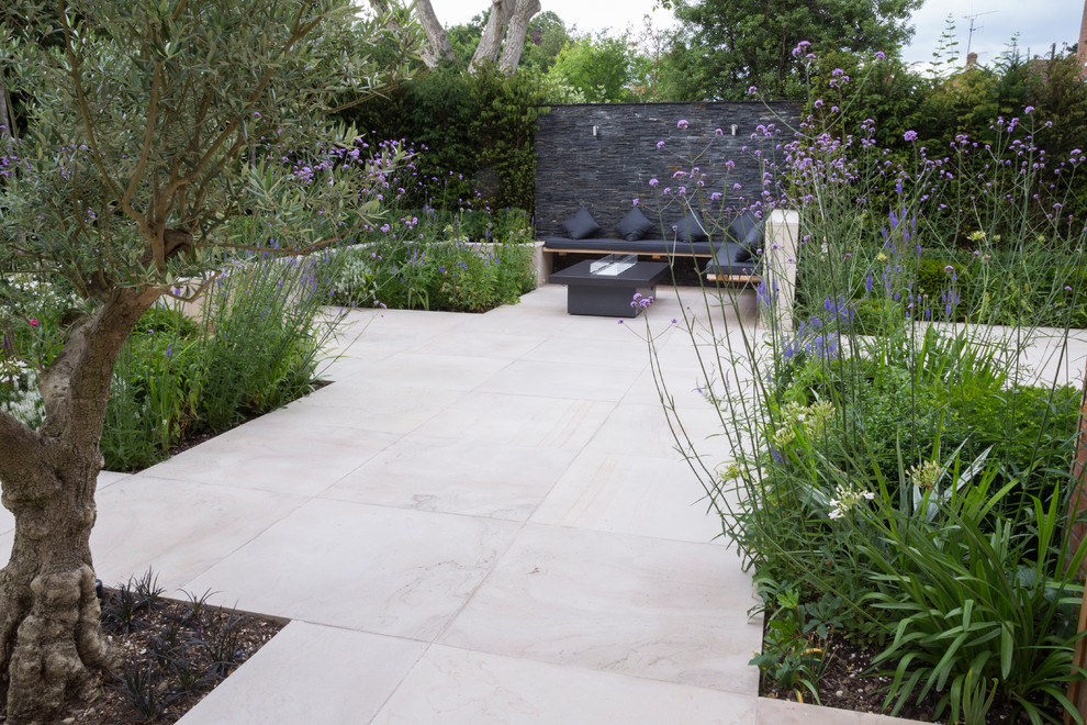 Contemporary patio in Essex with natural stone pavers, a fire feature and no cover.