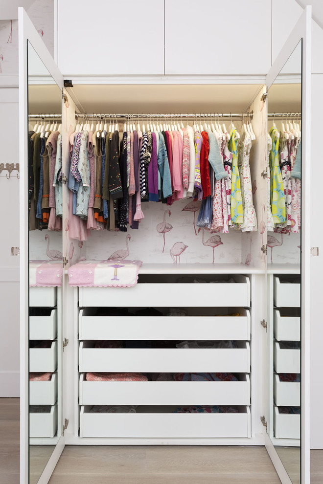 Design ideas for a contemporary women's built-in wardrobe in London with flat-panel cabinets and white cabinets.
