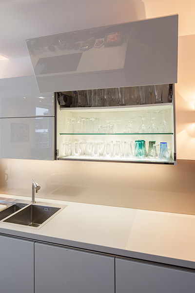 Küche in L-Form mit integriertem Waschbecken, flächenbündigen Schrankfronten, weißen Schränken, Quarzwerkstein-Arbeitsplatte, Küchenrückwand in Beige, Küchengeräten aus Edelstahl, Marmorboden und Kücheninsel