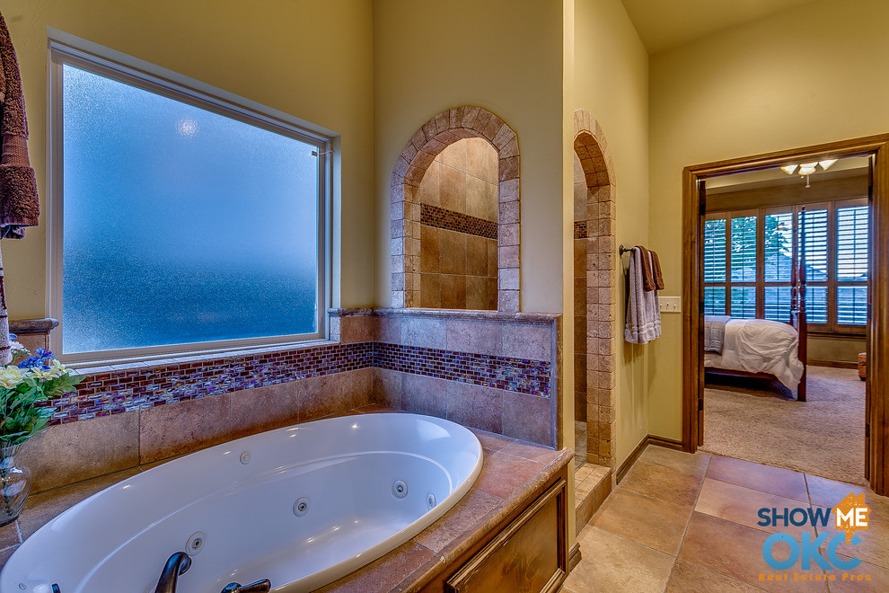 Inspiration for a large traditional master bathroom in Oklahoma City with a drop-in sink, raised-panel cabinets, granite benchtops, a drop-in tub, an open shower, ceramic tile and ceramic floors.
