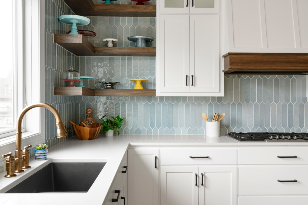 Exempel på ett vit vitt kök, med vita skåp, bänkskiva i kvarts, blått stänkskydd, ljust trägolv och en köksö