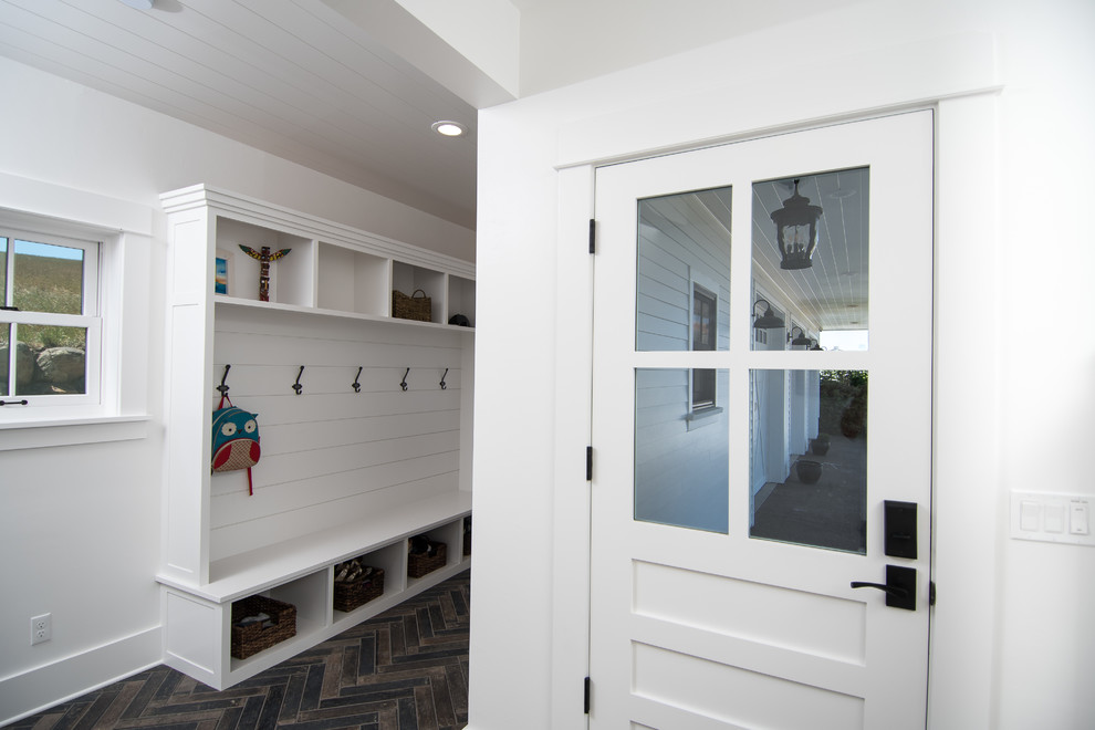 Photo of a mid-sized country mudroom in Portland with white walls, dark hardwood floors, a single front door and a white front door.