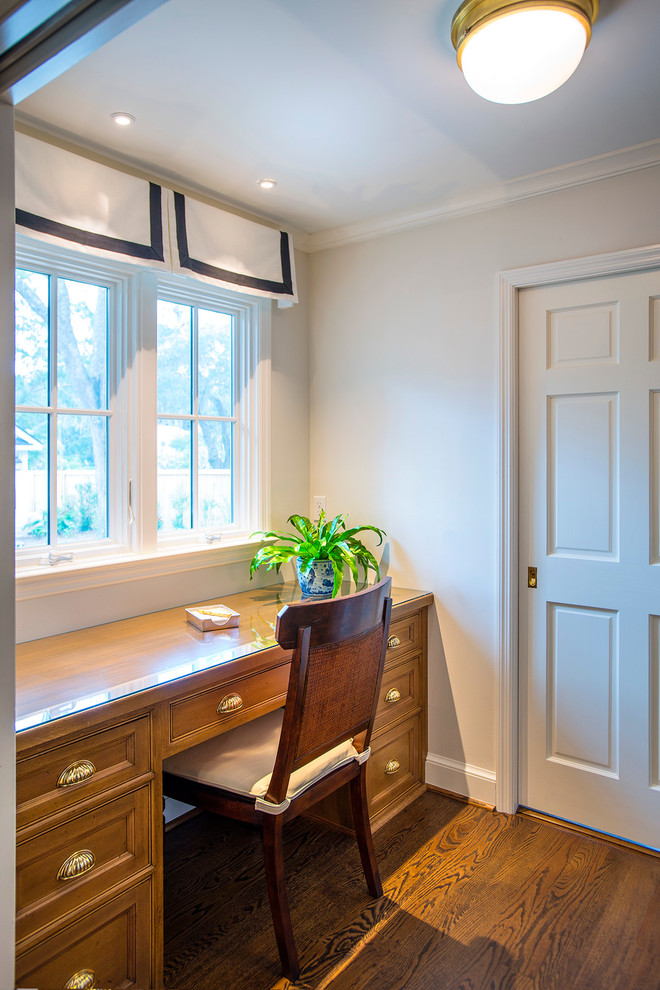This is an example of a small traditional study room in Charleston with white walls, medium hardwood floors, no fireplace, a built-in desk and brown floor.