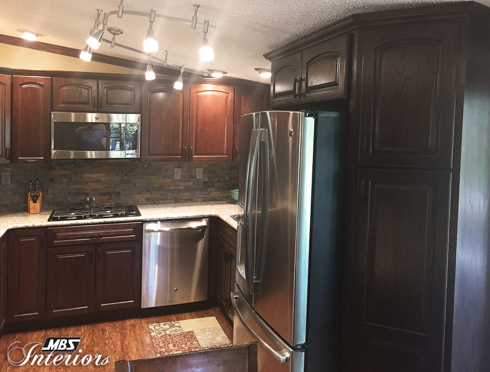 Enclosed kitchen - small transitional u-shaped medium tone wood floor enclosed kitchen idea with dark wood cabinets, gray backsplash, stone tile backsplash, stainless steel appliances, no island and an undermount sink
