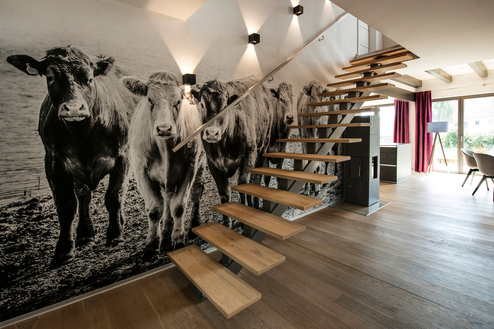 Photo of a mid-sized contemporary painted wood straight staircase in Munich with open risers and metal railing.