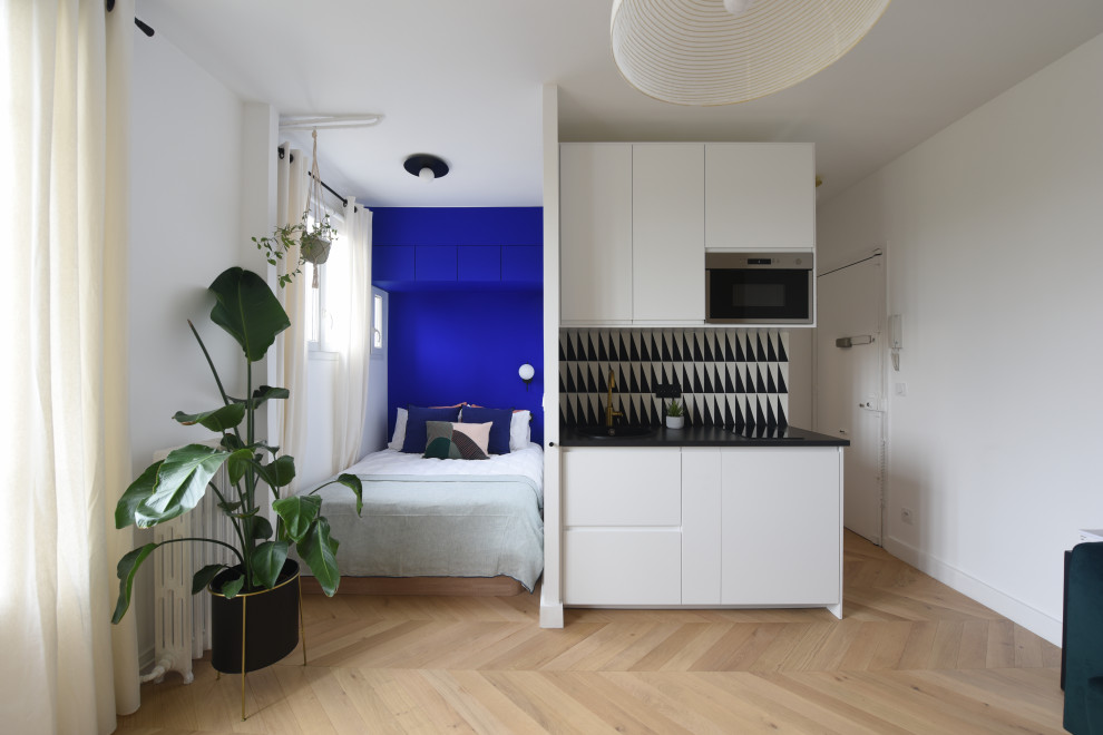 Small contemporary single-wall kitchen in Paris with a single-bowl sink, laminate countertops, multi-coloured splashback, cement tile splashback, laminate floors, no island and black worktops.