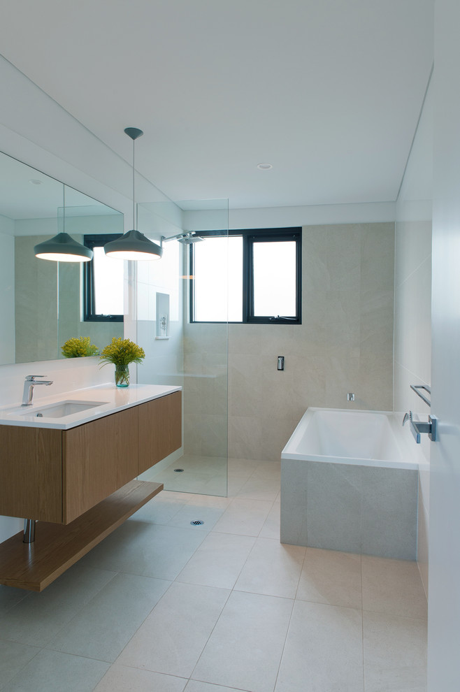 Design ideas for a mid-sized modern bathroom in Perth with flat-panel cabinets, medium wood cabinets, a drop-in tub and a curbless shower.