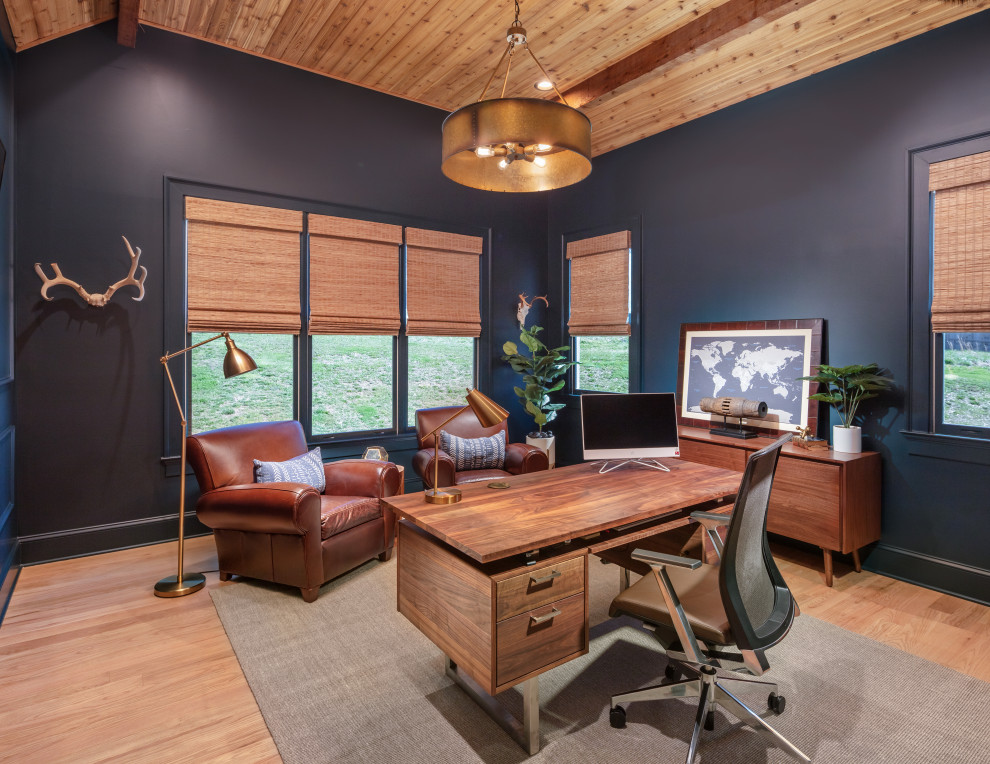 Photo of a mid-sized transitional home office in Atlanta with blue walls, light hardwood floors, a freestanding desk, brown floor, timber, decorative wall panelling and a library.