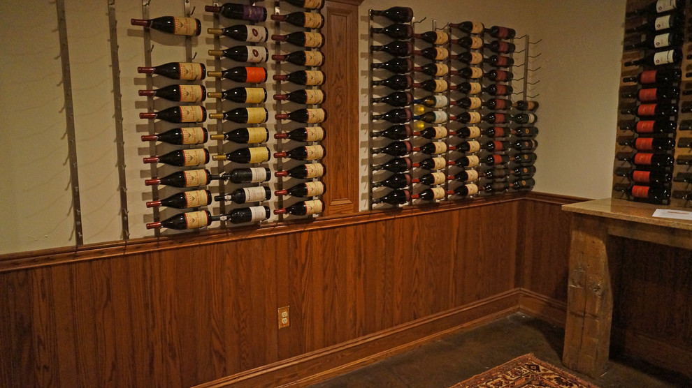 Aménagement d'une cave à vin classique de taille moyenne avec sol en béton ciré et un présentoir.