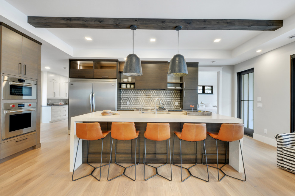 Moderne Wohnküche mit Küchengeräten aus Edelstahl, Kücheninsel, weißer Arbeitsplatte und freigelegten Dachbalken in Minneapolis