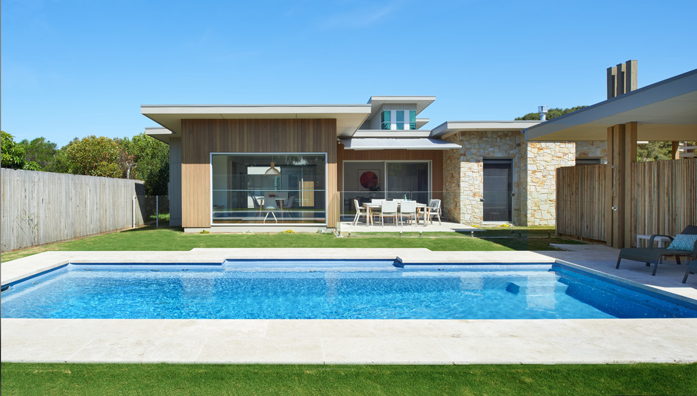 This is an example of a large contemporary backyard rectangular lap pool in Melbourne with concrete slab.