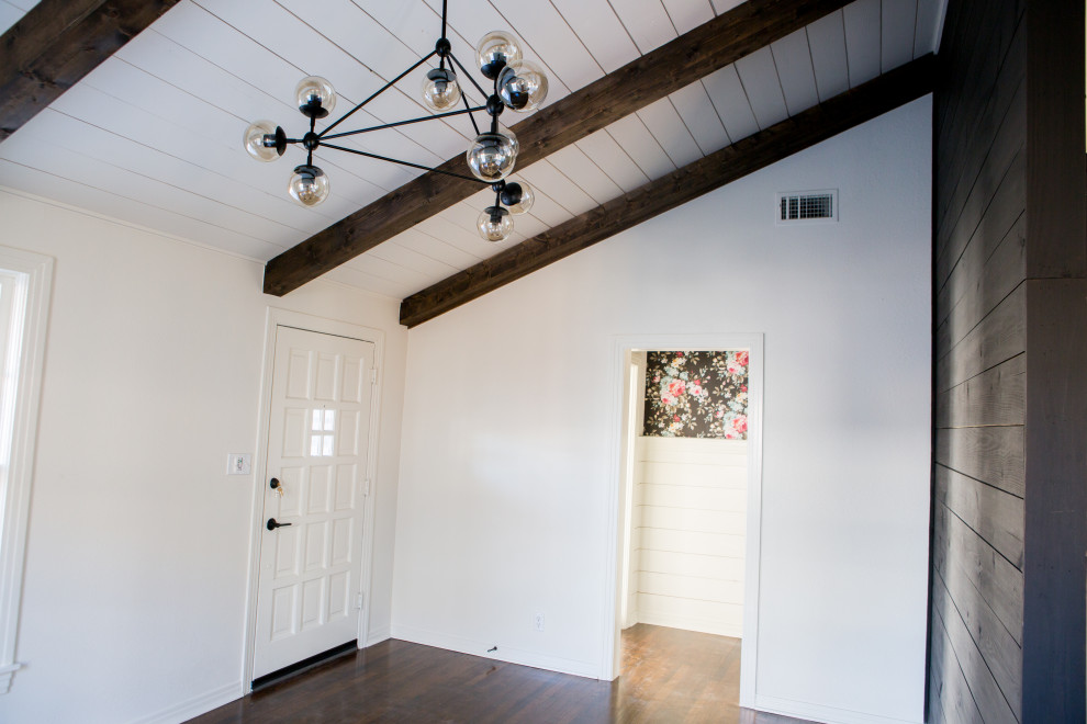Inspiration for a mid-sized country front door in Dallas with white walls, dark hardwood floors, a white front door, brown floor, exposed beam and panelled walls.