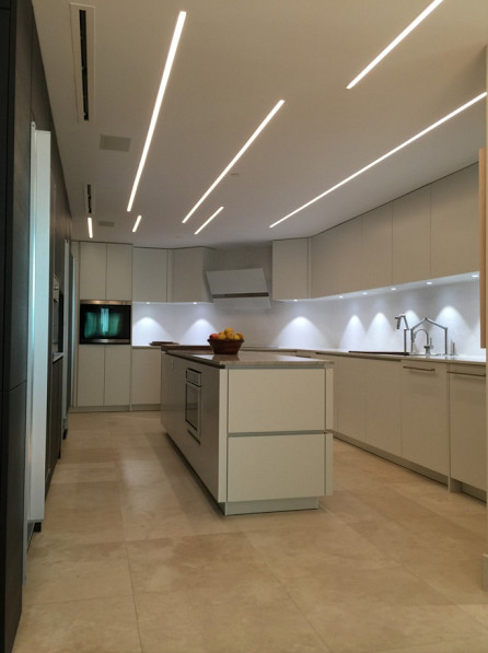 Design ideas for a mid-sized modern galley kitchen in Miami with flat-panel cabinets, white cabinets, stainless steel appliances, with island, granite benchtops and travertine floors.