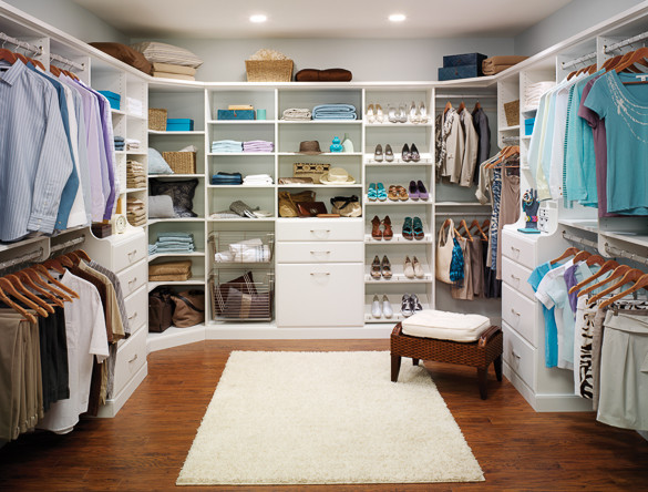 This is an example of a mid-sized traditional gender-neutral walk-in wardrobe in Jacksonville with flat-panel cabinets, white cabinets, dark hardwood floors and brown floor.
