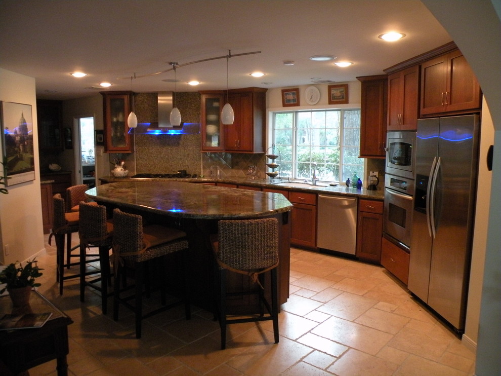 Inspiration for a mid-sized transitional u-shaped limestone floor eat-in kitchen remodel in Houston with an undermount sink, shaker cabinets, medium tone wood cabinets, granite countertops, beige backsplash, ceramic backsplash, stainless steel appliances and an island