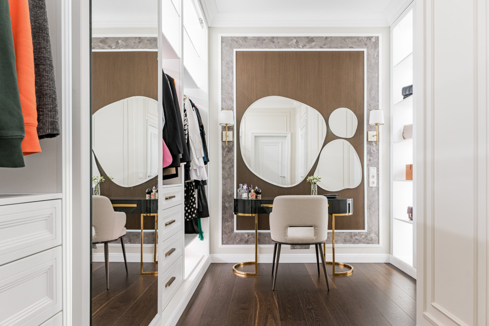 This is an example of an expansive classic gender neutral walk-in wardrobe in Yekaterinburg with recessed-panel cabinets, white cabinets, dark hardwood flooring, brown floors and a drop ceiling.