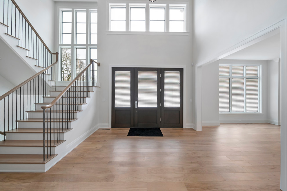 Inspiration for a huge transitional light wood floor and brown floor foyer remodel in Chicago with gray walls