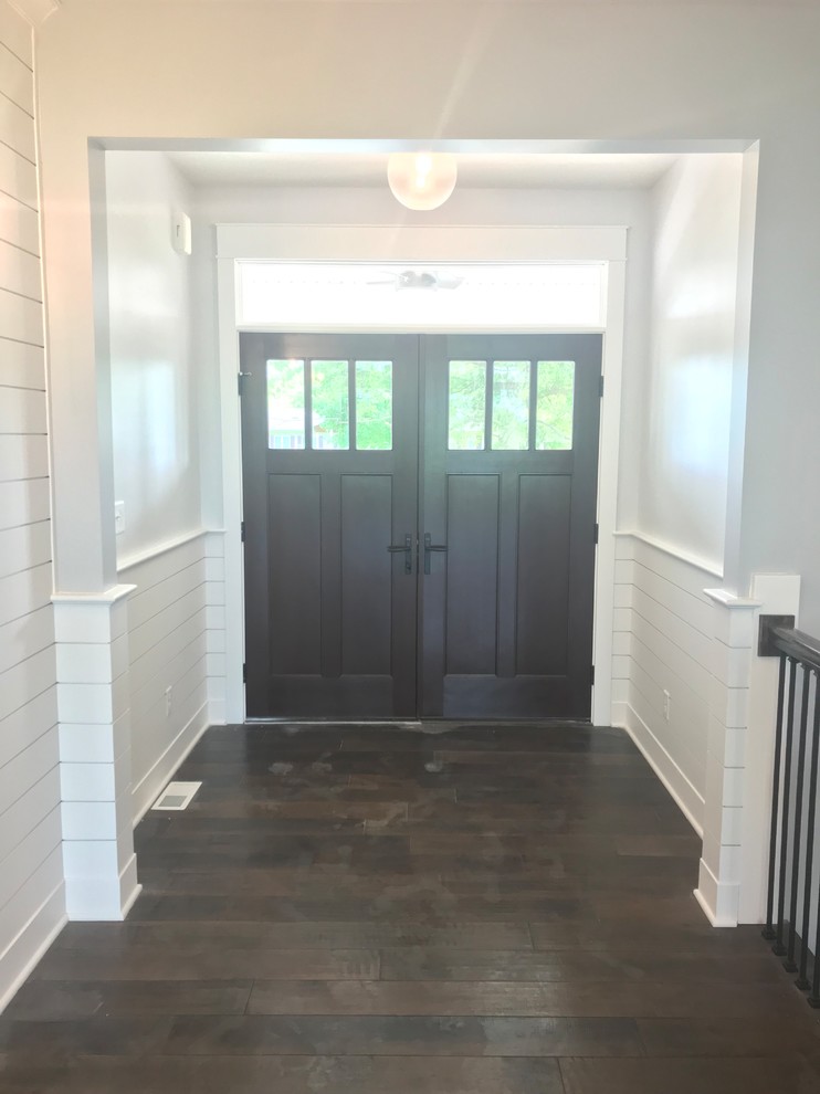 Example of a mid-sized transitional dark wood floor and brown floor front door design with white walls and a dark wood front door